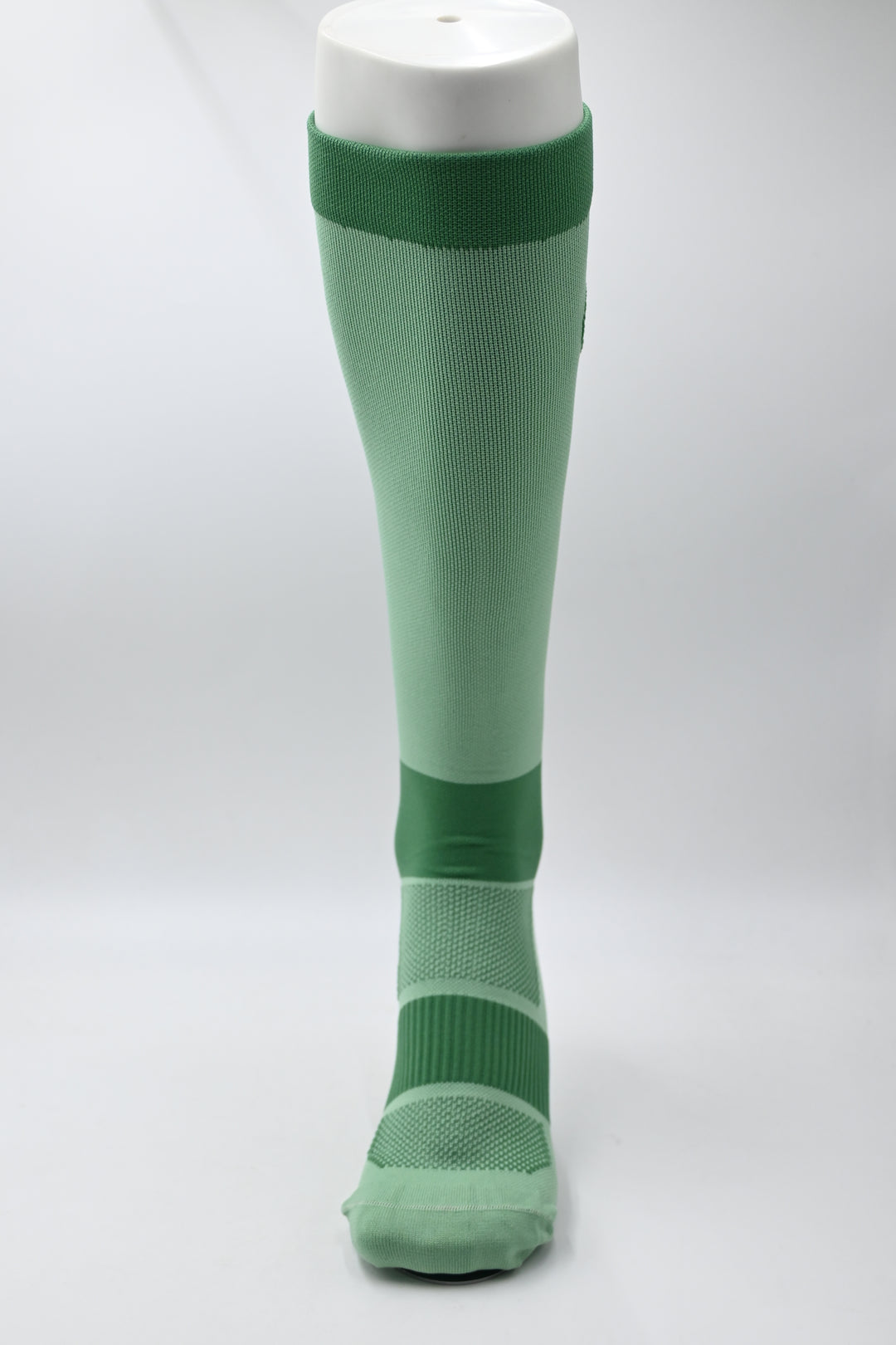 Green and white flashlight on a light gray background