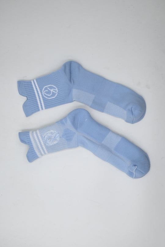 Pair of light blue socks with white stripes on a gray background