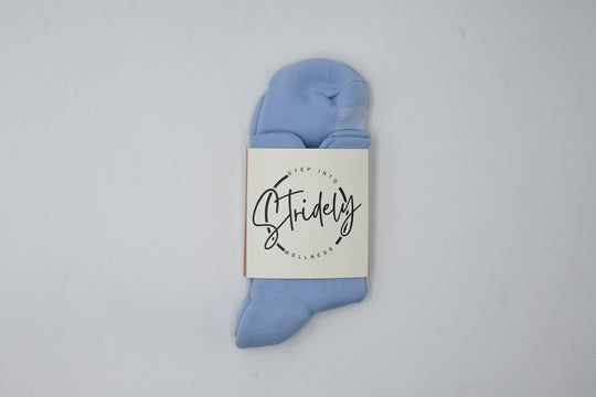 Light blue ankle sock with a branded label on a light gray background